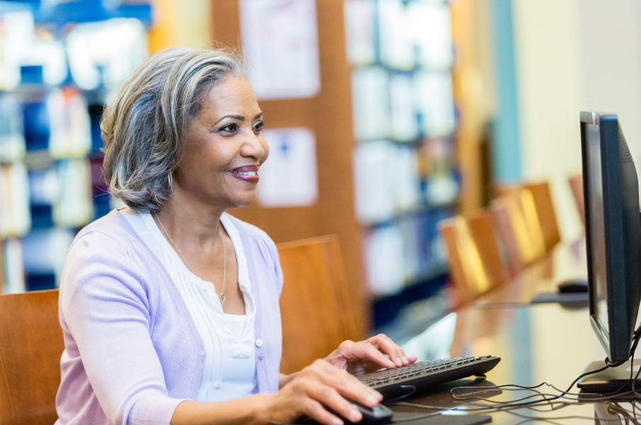 Woman uses computer in public library.